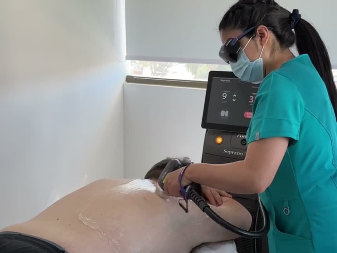 Profesional de Vitabella Calama aplicando Soprano Titanium en la espalda de un hombre